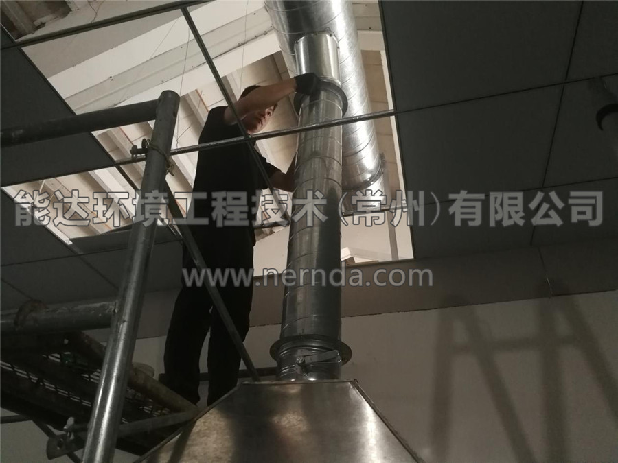 能達(dá)環(huán)境設(shè)計(jì)生產(chǎn)的型號(hào)為DAHT-7000熔噴布廢氣處理設(shè)備的排氣筒正在從房頂穿出進(jìn)行安裝調(diào)試作業(yè)2
