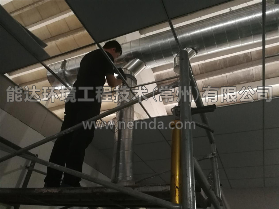 能達(dá)環(huán)境設(shè)計(jì)生產(chǎn)的型號(hào)為DAHT-7000熔噴布廢氣處理設(shè)備的排氣筒正在從房頂穿出進(jìn)行安裝調(diào)試作業(yè)1